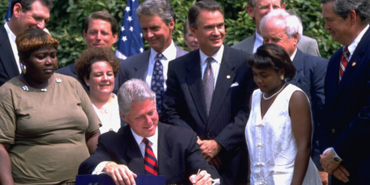 Pres. Bill Clinton (C) signing controversial welfare reform bill in White House Rose Garden, w. former welfare recipients, VP Gore (2R), Sen. John Breaux (3L) & others. (Photo by Dirck Halstead/Getty Images)