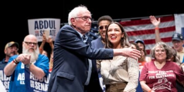 Sen. Bernie Sanders greets Rep. Alexandria Ocasio-Cortez at The People v. The Powerful rally at the Detroit Opera House on July 18, 2026, in Detroit, Michigan.