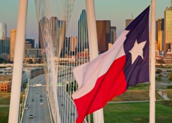 A Texas state flag waves near the Margaret Hunt Hill Bridge in downtown Dallas, Texas.