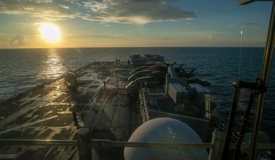 This image from video provided by U.S. Central Command shows U.S. sailors and Marines aboard USS Tripoli arriving in the U.S. Central Command area of responsibility, March 27, 2026. (U.S. Central Command via AP) ** FILE **