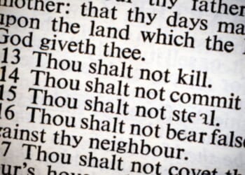 A photo of the Ten Commandments on a lit piece of paper is pictured.