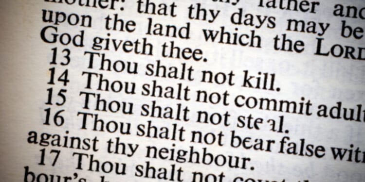 A photo of the Ten Commandments on a lit piece of paper is pictured.