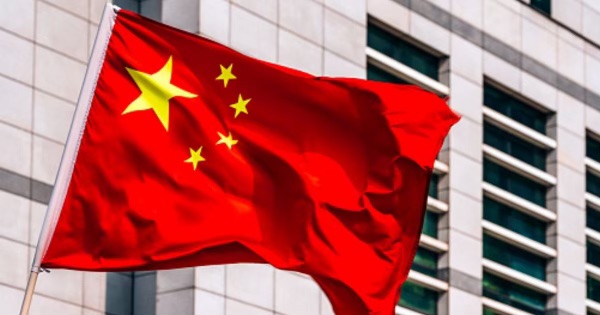 A Chinese flag flies near a large building.