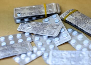 Metallic pill packets lay on a wooden table in New York on May 7, 2026.