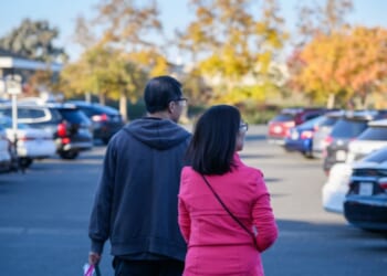 A couple carrying a shopping bag in the autumn.