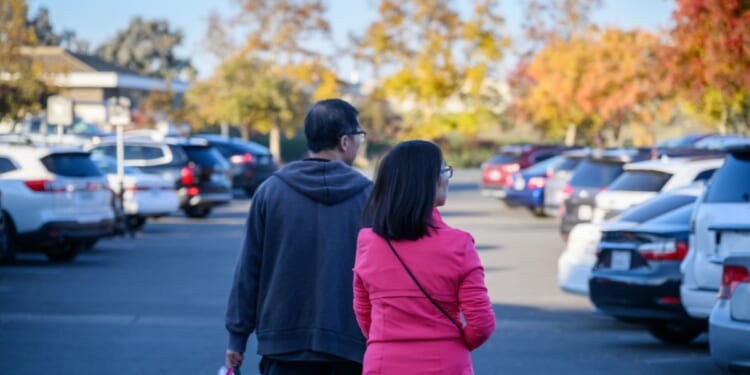 A couple carrying a shopping bag in the autumn.