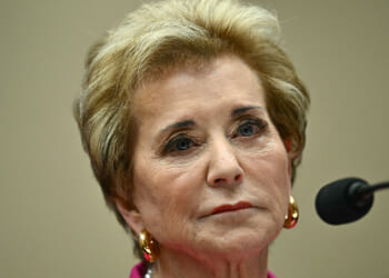 Department of Education staff recommended against renewing the ABA's ability to accredit law schools. Pictured: Linda McMahon, a woman with short blond hair, wearing gold earrings and a pink top, looks serious while sitting in front of a microphone during a formal event.