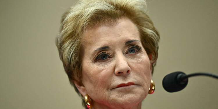 Department of Education staff recommended against renewing the ABA's ability to accredit law schools. Pictured: Linda McMahon, a woman with short blond hair, wearing gold earrings and a pink top, looks serious while sitting in front of a microphone during a formal event.