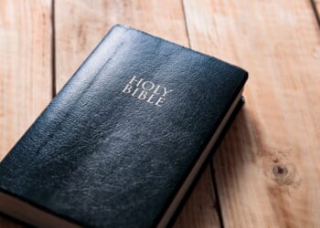 A Bible on a wooden table background.