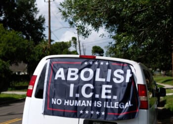 A banner reading "Abolish ICE, No Human is Illegal" is displayed on a van in Houston, Texas.