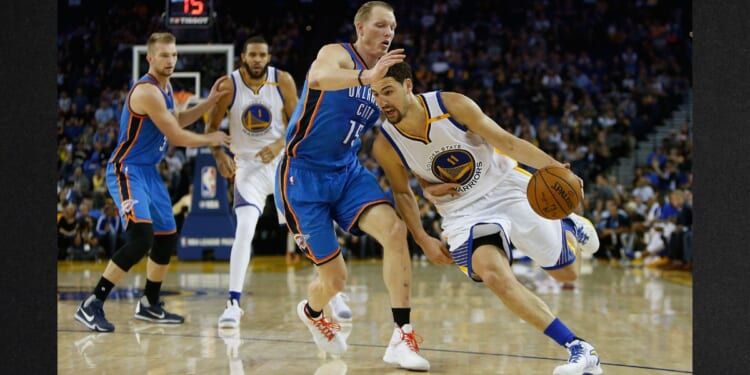 Klay Thompson #11 of the Golden State Warriors drives past Kyle Singler #15 of the Oklahoma City Thunder at Oracle Arena on Nov. 3, 2016, in Oakland, California.