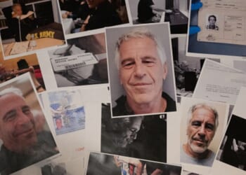 Pictures of Epstein are scrambled upon a wooden table.