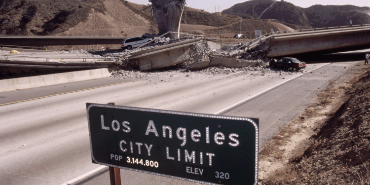 A collapsed freeway overpass blocks a deserted highway near a Los Angeles City Limit sign, with hills in the background and one car parked near the rubble.