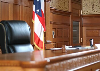 A wooden courtroom sits empty.