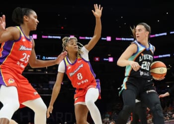 Sabrina Ionescu of the New York Liberty handles the ball against Alyssa Thomas and Monique Akoa Makani of the Phoenix Mercury during the first half of the WNBA game at Mortgage Matchup Center on Aug. 1, 2026, in Phoenix, Arizona.