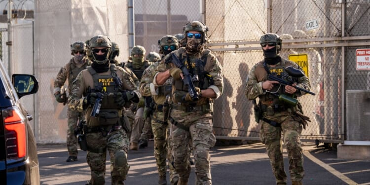 Immigration and Customs Enforcement agents run out of Delaney Hall Immigration Detention Center as they protect vehicles during a shift change on June 7, 2026, in Newark, New Jersey.