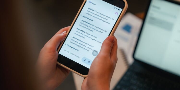 A woman looks at a phone screen with an AI user interface displayed on it.