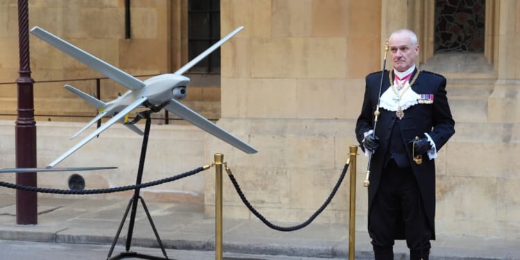 Gentleman Usher of the Black Rod, Lieutenant General Ed Davis, stands by a drone in Speaker's Square in central London on March 17, 2026, during a visit to the Palace of Westminster, home to Britain's Houses of Parliament, by Ukraine's President.