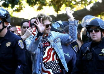 Right-wing commentator Milo Yiannopoulos is escorted by police officers after appearing at a free-speech rally at U.C. Berkeley on Sept. 24, 2017, in Berkeley, California.