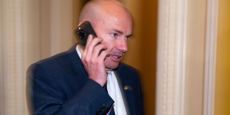 Sen. Mike Lee speaks on his phone.