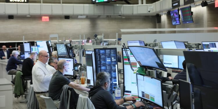 Traders work on the floor of the New York Stock Exchange during morning trading on March 10, 2026, in New York City.