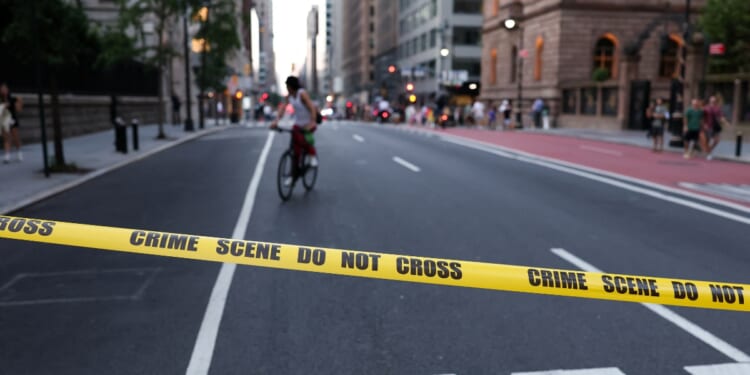 A cyclist is seen behind crime scene tape as police respond to a shooting incident in the Midtown Manhattan neighborhood of New York on July 28, 2025.