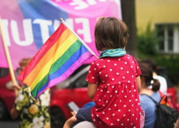 A child sits on her mother's shoulders at an LGBT pride event.