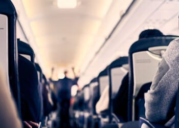The interior of a plane as passengers sit in their seats.