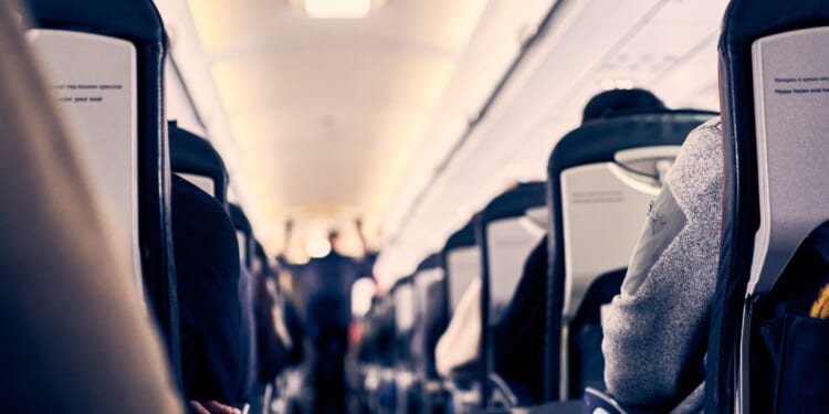 The interior of a plane as passengers sit in their seats.