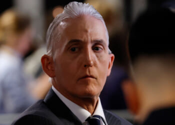 Trey Gowdy with slicked-back gray hair in a suit and tie looks to the side with a serious expression.