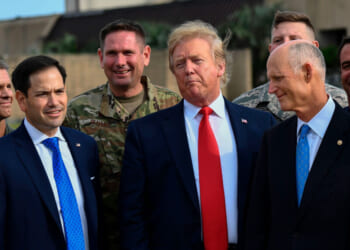 Donald Trump looks on next to US Senators Marco Rubio and Rick Scott (R-FL) .