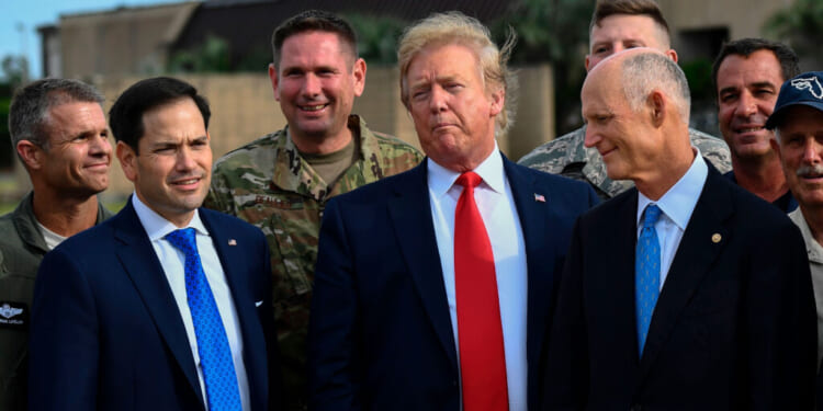 Donald Trump looks on next to US Senators Marco Rubio and Rick Scott (R-FL) .