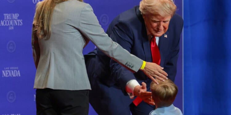 President Donald Trump greets a child onstage during an event at Red Rock Casino Resort and Spa on Wednesday in Las Vegas, moments before Trump turned on his grandfather switch.