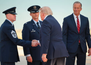 resident Donald Trump is greeted by Senate Majority Leader John Thune (R-SD) (right) on the tarmac after landing in Air Force One.
