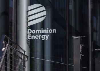 The Dominion Energy logo and name are displayed on the glass entrance of a modern building, with reflections and metal railings visible nearby.