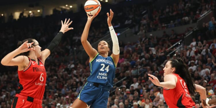 Napheesa Collier shoots a basketball as players surround her on the court in Portland, Oregon on August 12, 2026.