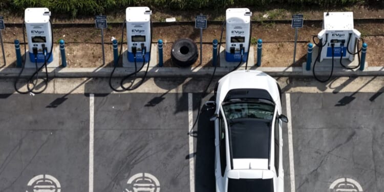 In an aerial view, an electric vehicle charges at an EVgo electric charger on March 30, 2026, in Monrovia, California.