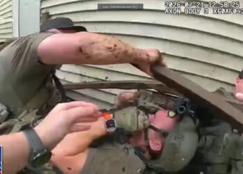 The team of officers fell to the ground, with broken lumber all around them.