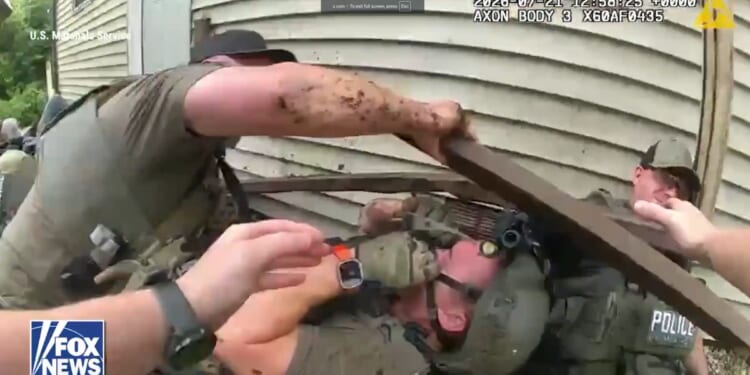 The team of officers fell to the ground, with broken lumber all around them.