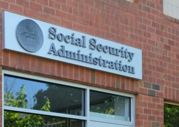 A brick Social Security Administration building stands in the sunshine.