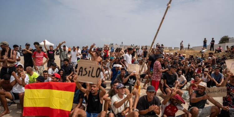 Migrants, mainly Moroccan, gather in a protest asking for asylum in El Trampolin beach on Aug. 16, 2026, in Ceuta, Spain.