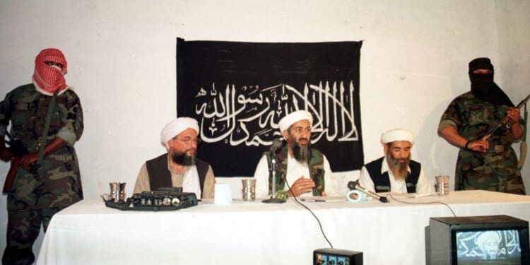 Armed men stand guard as terrorist Osama bin Laden and Ayman Al-Zawahiri address a news conference on May 26, 1998, in Afghanistan.
