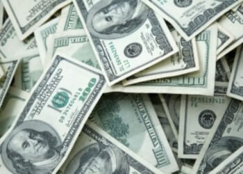 Hundred dollar bills lay across a table.