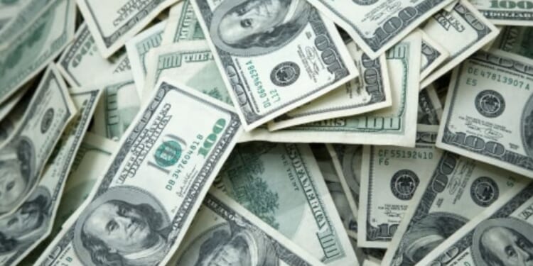 Hundred dollar bills lay across a table.