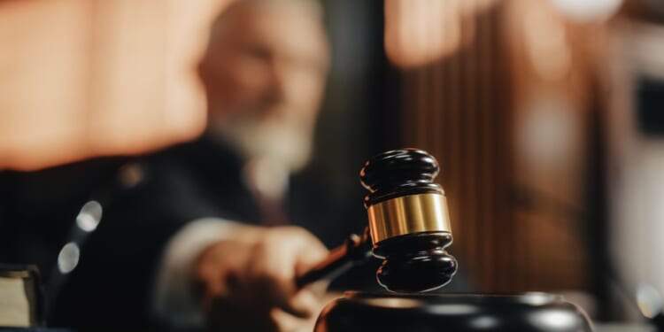 A judge brings down his gavel in a courtroom.