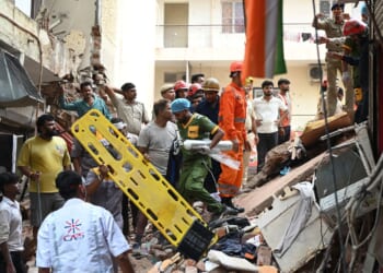 Building collapse in New Delhi kills 1 and traps dozens of others