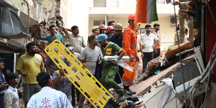 Building collapse in New Delhi kills 1 and traps dozens of others