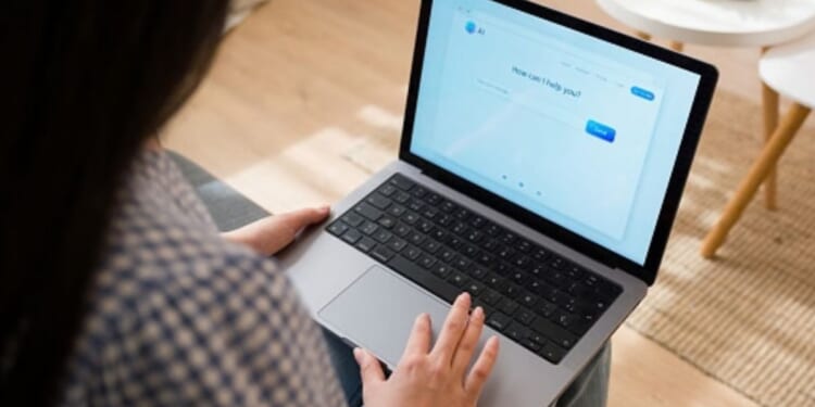 A woman types on her computer to an AI chat bot.