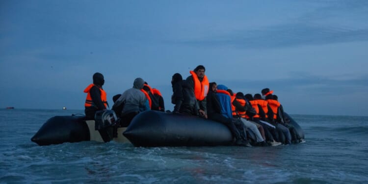 Migrants sit aboard a dinghy as they prepare to sail into the English Channel on Sept. 21, 2026, in Gravelines, France.