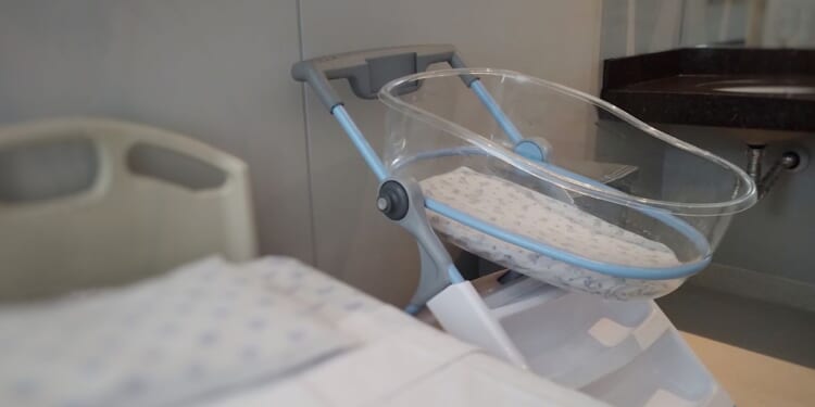 An acrylic crib for a newborn in a maternity room.